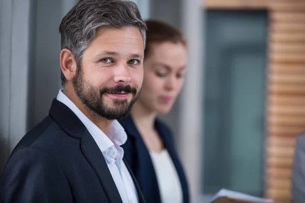 Glimlachende zakenman in functie — Stockfoto