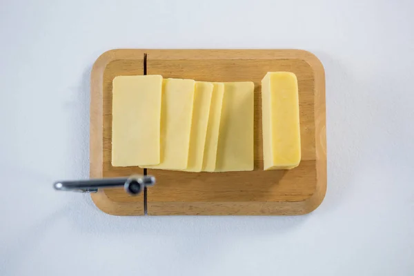 Placa de corte de queijo com fatias de queijo — Fotografia de Stock