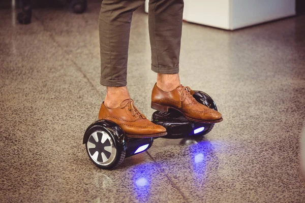 Business executive standing on hoverboard — Stock Photo, Image