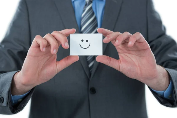 Empresário segurando cartão de visitante com smiley — Fotografia de Stock