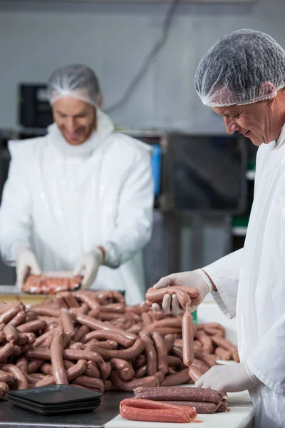 Carniceros procesando salchichas —  Fotos de Stock