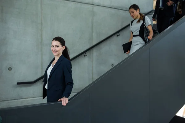 Mujer de negocios con colegas subiendo escaleras —  Fotos de Stock