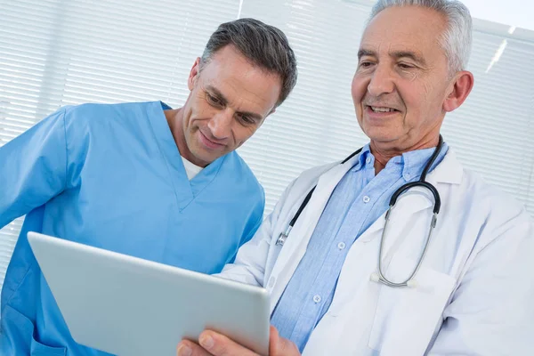 Kirurg och läkare diskutera över tablett — Stockfoto