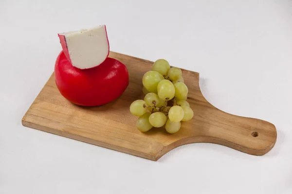 Fromage rouge et raisins sur planche de bois — Photo