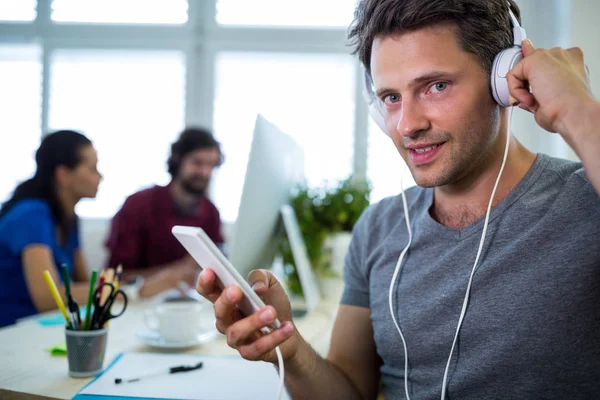 Business executive listening to music on phone — Stock Photo, Image