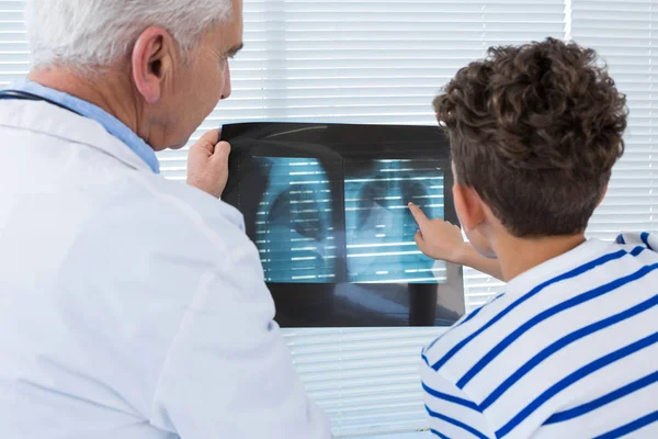 Docteur discutant du rapport de radiographie avec le patient — Photo