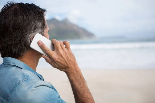 Man talar i mobiltelefon på stranden — Stockfoto