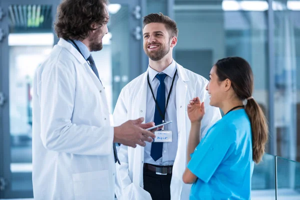 Médico segurando tablet digital tendo uma discussão com colegas — Fotografia de Stock