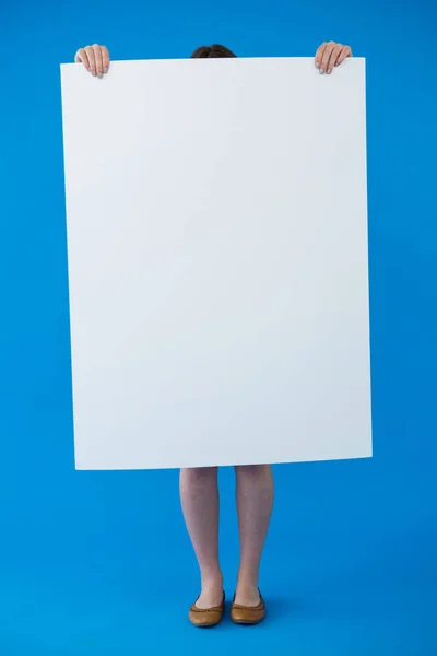 En kvinne med et tomt skilt foran ansiktet. – stockfoto