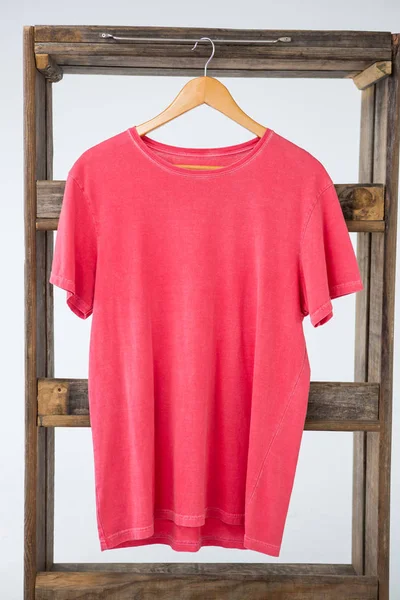 Pink t-shirt hanging on wooden frame — Stock Photo, Image