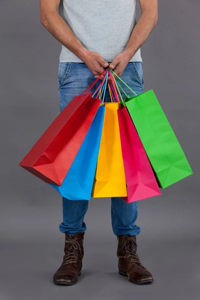 Muž hospodářství pestrobarevné nákupní tašky — Stock fotografie