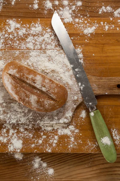 Selský chléb s nožem na prkénku — Stock fotografie