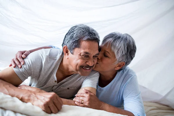 Mujer mayor dando un beso en las mejillas del hombre — Foto de Stock