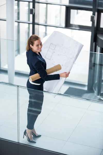 Femme d'affaires au couloir de bureau avec un plan directeur — Photo