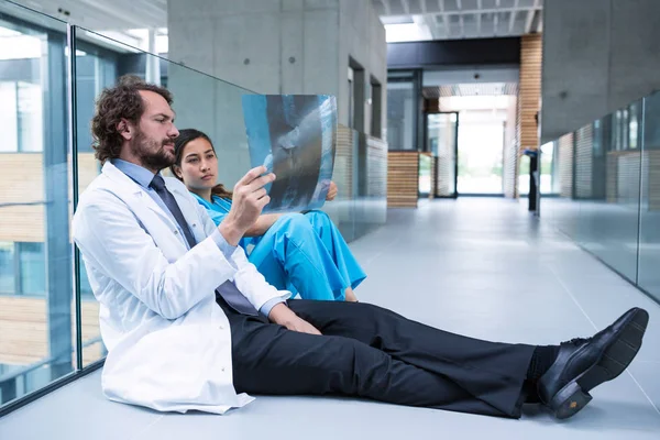 Stressad läkare och sjuksköterska sitter på golvet — Stockfoto