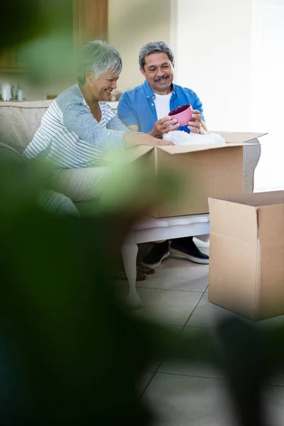Senior couple unpackaging cardboard box — Stock Photo, Image