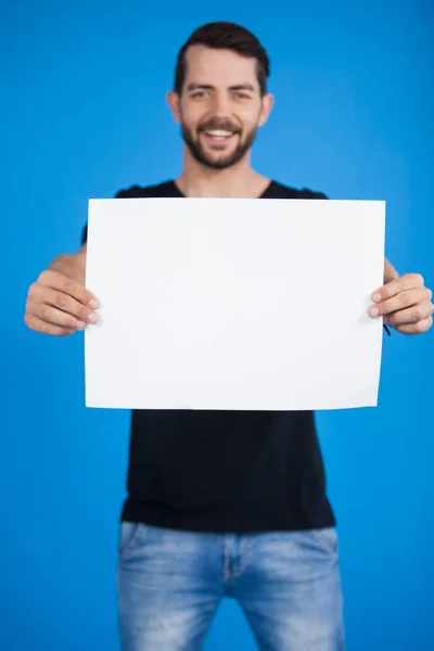 Bonito homem segurando um cartaz em branco — Fotografia de Stock