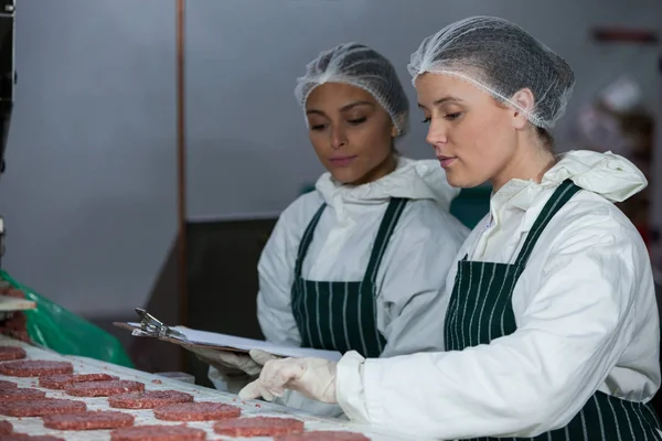 Butchers maintaining records on clipboard — Stock Photo, Image