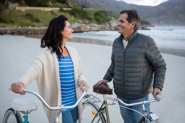 Couple standing with bicycle interacting — Stock Photo, Image