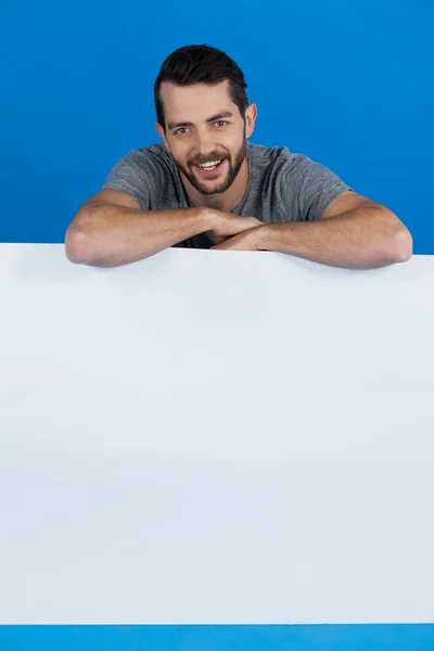 Handsome man holding a blank placard — Stock Photo, Image