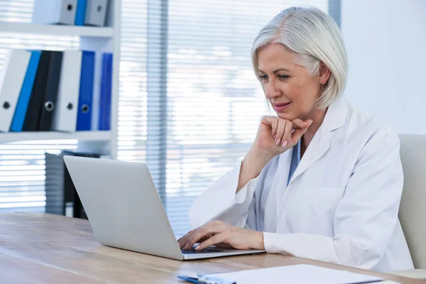 Médica feminina cuidadosa trabalhando em seu laptop — Fotografia de Stock