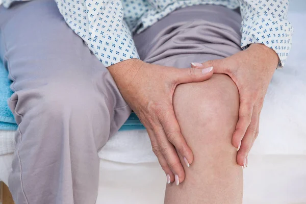 Paciente tocando seu joelho lesionado — Fotografia de Stock