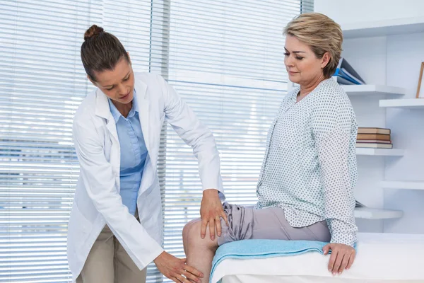 Врач осматривает колено пациента — стоковое фото