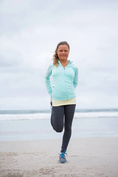 Frau macht Dehnübungen am Strand — Stockfoto