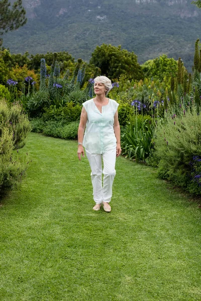 Senior Kvinna promenader i gräsmatta — Stockfoto