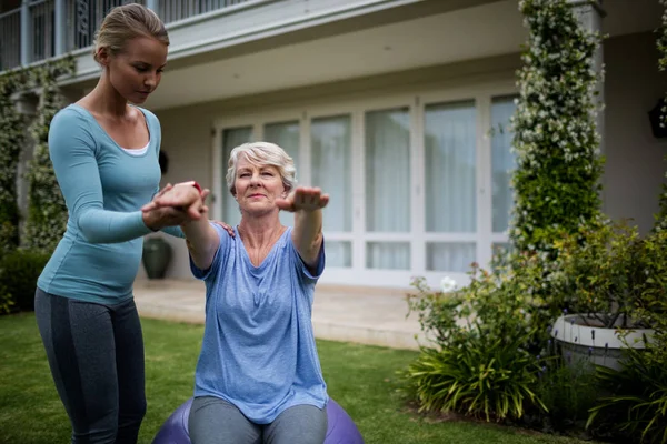 Entrenador ayudar a la mujer en la realización de ejercicio — Foto de Stock