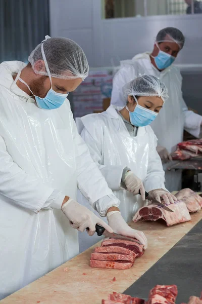 Slagers snijden van vlees in vlees fabriek — Stockfoto