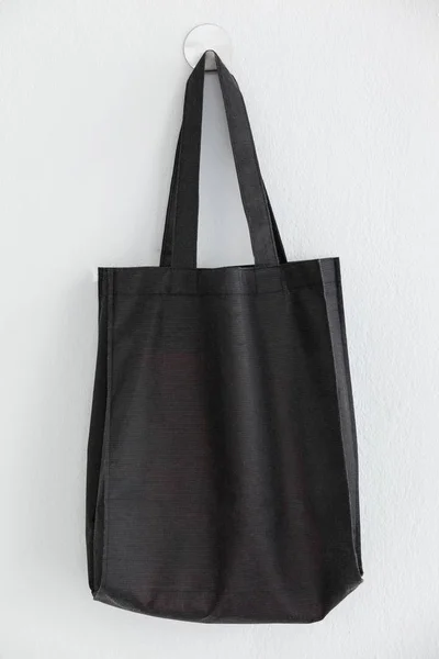 Black bag hanging on wall — Stock Photo, Image