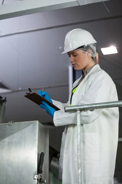 Técnico examinando máquina de processamento de carne — Fotografia de Stock