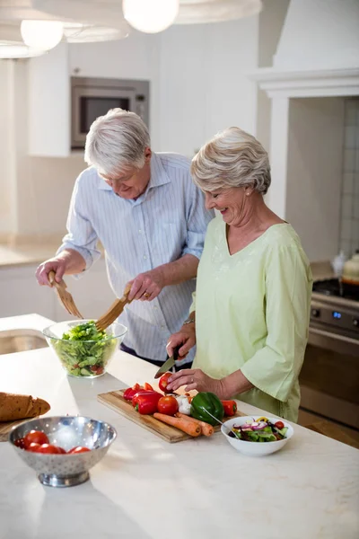 Äldre par förbereder grönsakssallad — Stockfoto