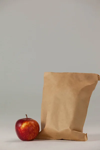 Bolsa de almuerzo de papel marrón con manzana roja —  Fotos de Stock