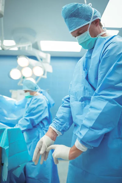 Chirurgien masculin portant des gants chirurgicaux — Photo
