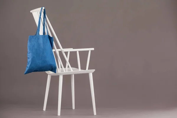 Blue bag hanging on a white chair — Stock Photo, Image