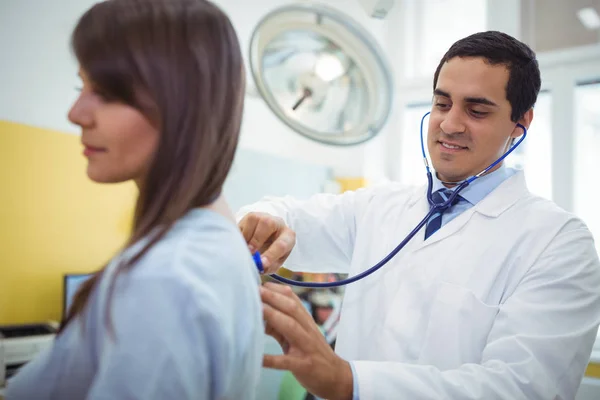 Doutor examinando uma paciente do sexo feminino — Fotografia de Stock