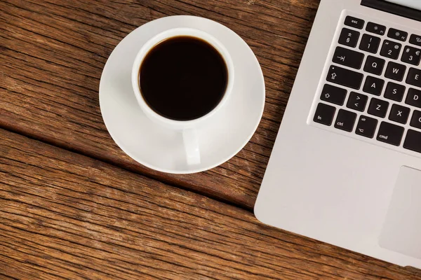 Laptop e xícara de café na mesa — Fotografia de Stock