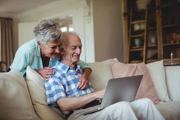 Seniorenpaar benutzt Laptop im Wohnzimmer — Stockfoto