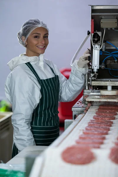 Kvinnliga slaktare bearbetning hamburgare bulle — Stockfoto