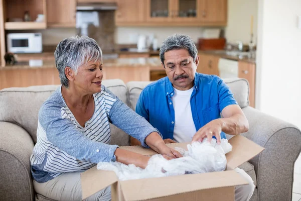 Casal sênior desembalagem caixa de papelão — Fotografia de Stock