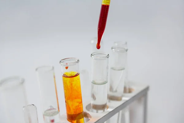 Blood sample being drop into test tubes — Stock Photo, Image