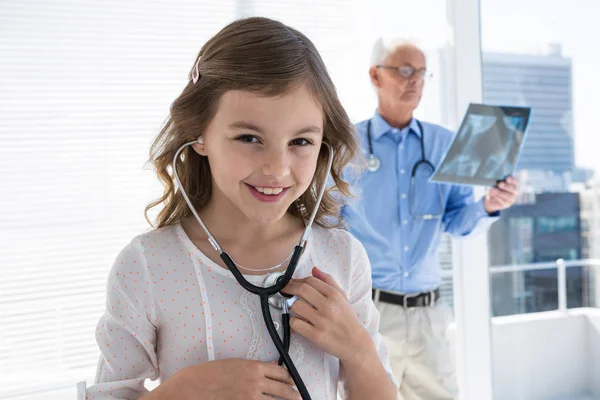 Девушка проверяет свое сердцебиение при помощи стетоскопа — стоковое фото