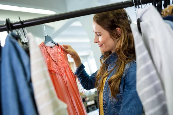 Žena dělá nakupování v obchodě s oděvy — Stock fotografie