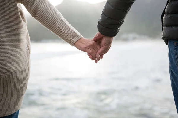 Pár držící se za ruce na pláži — Stock fotografie