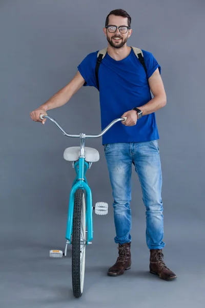 Мужчина в синей футболке и рюкзаке с велосипедом — стоковое фото