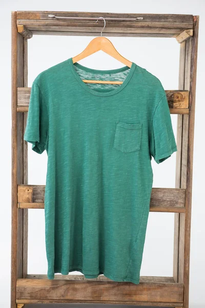 木製のフレームにぶら下がっている緑の t シャツ — ストック写真