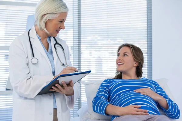 Беременная пациентка консультируется с врачом — стоковое фото