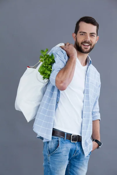 Bakkal çantası taşıyan ışık mavi tişörtlü adam — Stok fotoğraf